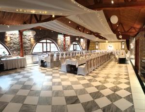 a set of tables in a room with a checkered floor at Achilles Park in Győr