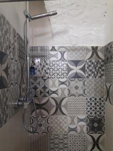 La salle de bains est pourvue d'une douche avec du carrelage noir et blanc. dans l'établissement Buze Luxury Suite, à Ostuni