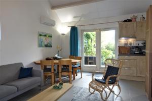 sala de estar con sofá, mesa y cocina en Vakantiehuis Merel, en Den Helder