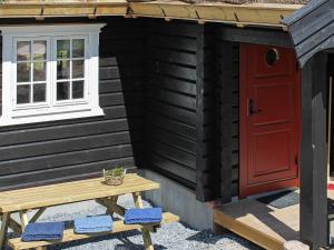 a red door and a bench in front of a house at 6 person holiday home in Svingvoll in Svingvoll