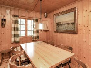 4 person holiday home in Bog By في Bogø By: غرفة طعام مع طاولة وكراسي خشبية