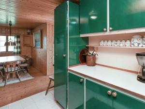 a kitchen with green cabinets and a dining room at 4 person holiday home in Bog By in Bogø By