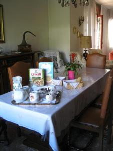La casa dei pini في Malnate: طاولة عليها قماش الطاولة البيضاء مع الطعام