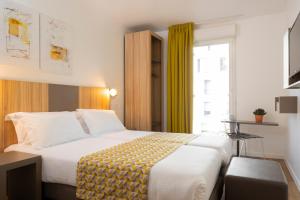 um quarto de hotel com uma cama e uma janela em Hôtel Lodge In Paris 13 em Paris