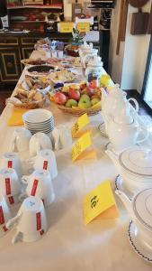 stół z talerzami, kubkami i miskami z jedzeniem w obiekcie Agriturismo Le Clementine w mieście Badia Polesine