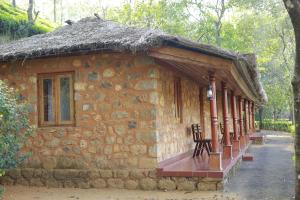 un pequeño edificio de piedra con techo de hierba en Saj Vagamon Hideout, en Vagamon