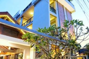 a building with a tree in front of it at Neakru Guesthouse and Restaurant in Kampot