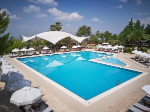 uma piscina num resort com cadeiras e guarda-sóis em Richmond Pamukkale Thermal em Pamukkale