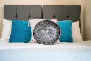 a wheel pillow sitting on a bed with blue pillows at Irene Court Cockermouth in Cockermouth