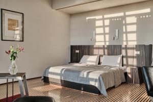 a bedroom with a bed and a vase of flowers at Hotel Monopol in Wrocław