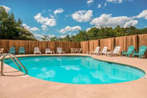 una piscina con sillas y una valla en Snuggle Bear Hideaway, en Pigeon Forge