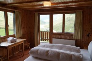 Un dormitorio con una cama, un escritorio y ventanas. en Hotel Bergalga, en Am Bach
