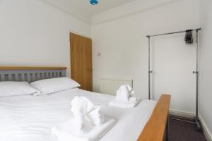 a bedroom with a white bed with towels on it at Railway Cottage in Newport