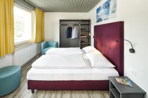 a bedroom with a large bed and a purple headboard at Basekamp Mountain Budget Hotel in Katschberghöhe
