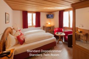 a hotel room with a bed and a desk at Hotel Hirschen - Grindelwald in Grindelwald