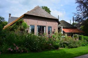 a brick house with a garden in front of it at B&B De Leeghpoel in Rumpt +14 photos