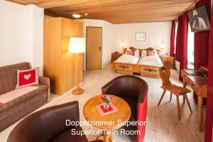 a bedroom with a bed and a table in a room at Hotel Hirschen - Grindelwald in Grindelwald