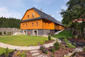 a large barn with an orange roof in a garden at CHATA MISTRIK in Donovaly