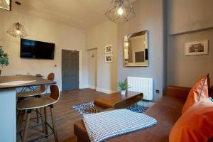 a living room with a couch and a table at The Matcham at Claremont Apartments in Leeds
