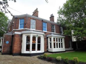 een groot rood bakstenen huis met witte deuren bij The Matcham at Claremont Apartments in Leeds