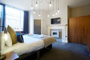 um quarto com uma cama grande e uma lareira em The Matcham at Claremont Apartments em Leeds