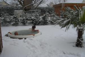 Una mujer en un jacuzzi en la nieve en Le Lagon, en Jargeau