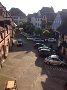 eine Gruppe von Autos, die auf einem Parkplatz geparkt sind in der Unterkunft Hôtel Restaurant Zum Schnogaloch in Obernai