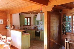 a kitchen with green cabinets in a wooden house at Chalet Blanche Neige in Gryon