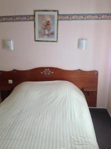 a bed with a wooden headboard in a bedroom at Hôtel Restaurant Zum Schnogaloch in Obernai