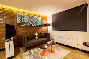 a living room with a couch and a large screen at Hostal Boutique Black Cat in Santiago