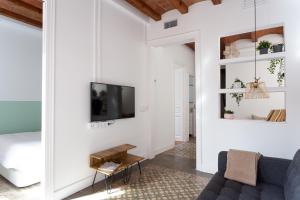 ein Wohnzimmer mit einem Sofa und einem TV in der Unterkunft Casa Cosi - Sant Gervasi 1 in Barcelona