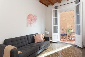 ein Wohnzimmer mit einem Sofa und einer offenen Tür in der Unterkunft Casa Cosi - Sant Gervasi 1 in Barcelona