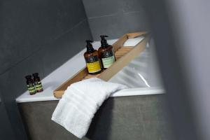 een plank in een badkamer met drie flessen op een bad bij Familia in Vathi