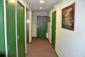 a hallway with green and white walls and doors at Hotel Les Bénédictins in Limoges