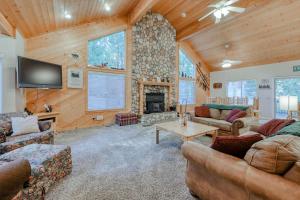 uma sala de estar com sofás, uma televisão e uma lareira em Hatcher's Hideaway em Shaver Lake