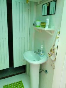 a bathroom with a white sink and a white door at Chambre indépendante in Porto Novo
