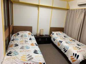 1 Schlafzimmer mit 2 Betten und 2 Fenstern in der Unterkunft 海天house in Beppu