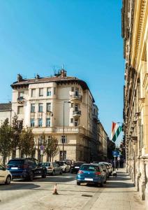 a city street with cars parked in front of a building at Boomerang Hostel in Budapest