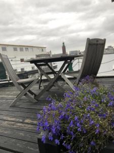 a picnic table and two chairs and flowers on a dock at Den Röda Båten in Stockholm