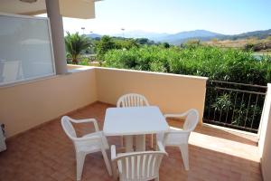 a white table and chairs on a balcony at Lo Smeraldo in Capoliveri +9 photos