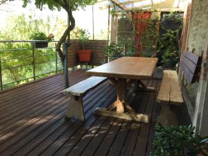 einem Holztisch und Bänken auf einer Terrasse in der Unterkunft Le clos d'André in Castelnaudary