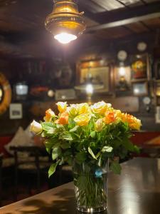 een vaas gevuld met gele en oranje bloemen op een tafel bij Den Röda Båten in Stockholm