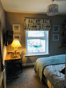 a bedroom with a bed and a desk and a window at Waterfront Apartment in Scarborough