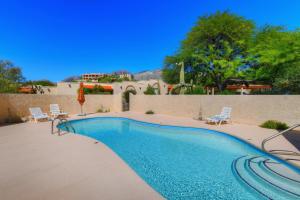 uma piscina com duas cadeiras e uma mesa em Esplendora em Tucson