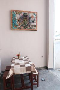 uma mesa com uma toalha de mesa xadrez na parede em Rumah Marianne em Sorong