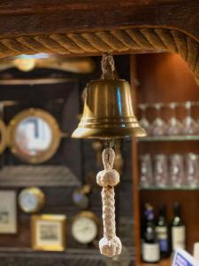 a bell with a tassel hanging from a shelf with clocks at Den Röda Båten in Stockholm