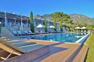 a swimming pool with lounge chairs and umbrellas at a resort at Apartment Safak, LaVanta, Kalkan in Kalkan