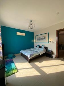 ein Schlafzimmer mit einem Bett und einer blauen Wand in der Unterkunft Majestic_vip in Half Moon Bay