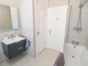 ein Badezimmer mit einem Waschbecken und einer weißen Tür in der Unterkunft Seacoast Cottage in Castlerock + 37 Fotos