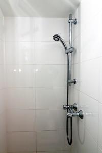 una ducha con cabezal de ducha en un baño en Kings Cross Hotel London, en Londres 45 fotos más
